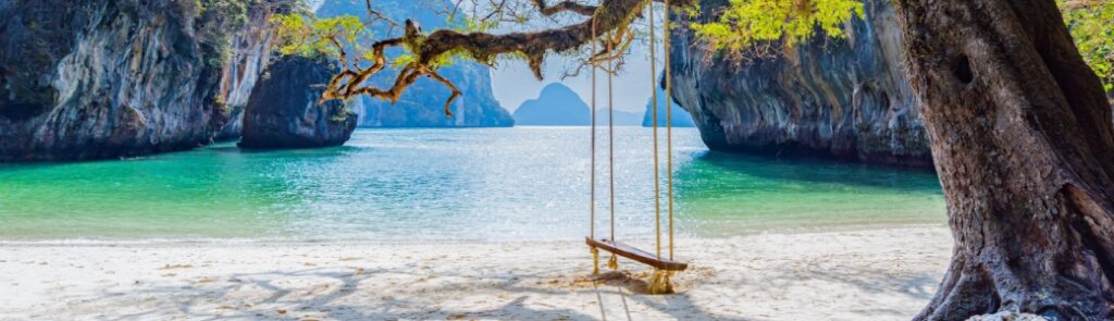 A beach with a swing hanging from a tree in Laos.