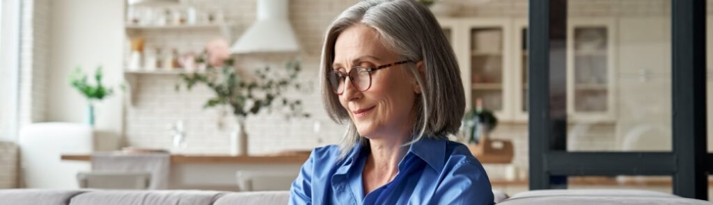 A woman in her 60s checking something on her mobile phone.