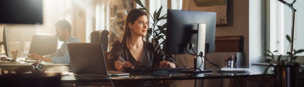 A woman using a computer in an office.